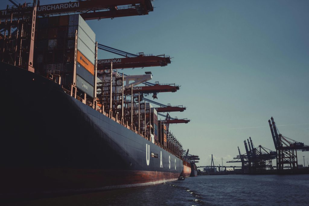 pexels photo 1095814 1095814 A large cargo ship docked at Hamburg Harbor, cranes loading containers under a clear sky.